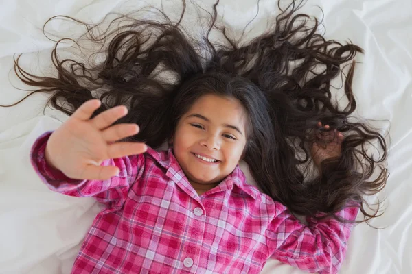 Sorrindo menina deitada na cama — Fotografia de Stock