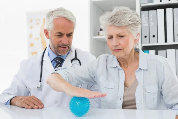 Male doctor with senior patient using stress buster ball — Stock Photo, Image