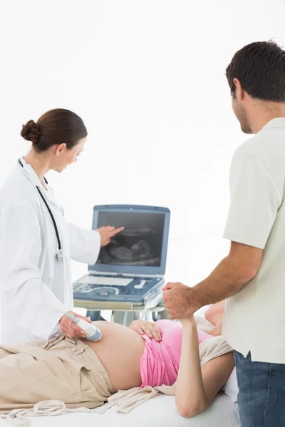 Doctor showing ultrasound screen to couple — Stock Photo, Image