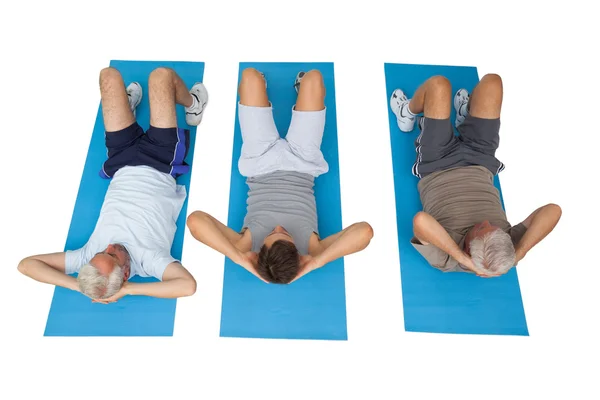 Full length of three men doing abdominal crunches — Stock Photo, Image