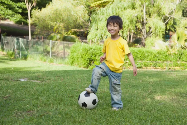 Netter kleiner Junge mit Fußball steht im Park — Stockfoto