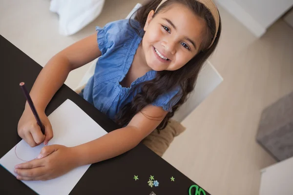 Sonriente chica dibujo en la mesa — Foto de Stock