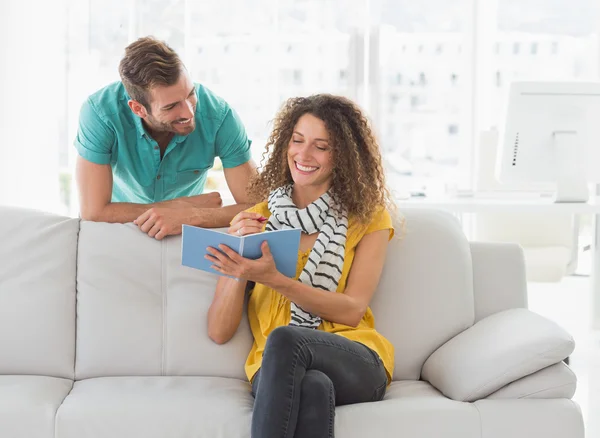 Sorridente donna mostrando il suo collega suo notebook — Foto Stock