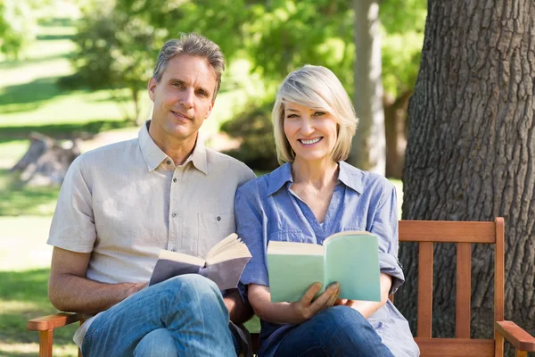 Coppia con libri seduta su panca — Foto Stock