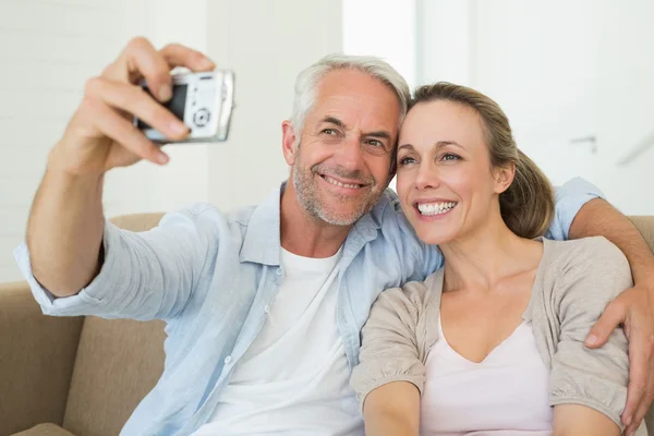 Szczęśliwa para przy selfie razem na kanapie — Zdjęcie stockowe
