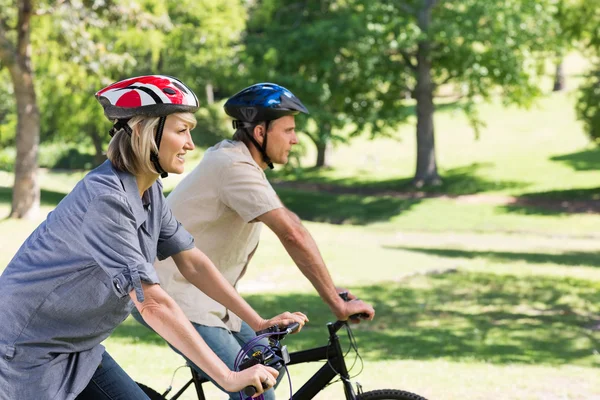 Lyckliga paret cykling i park — Stockfoto