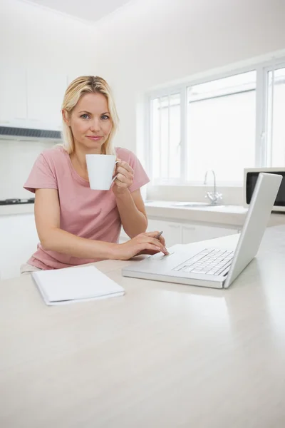 Mujer usando el ordenador portátil mientras bebe café — Foto de Stock