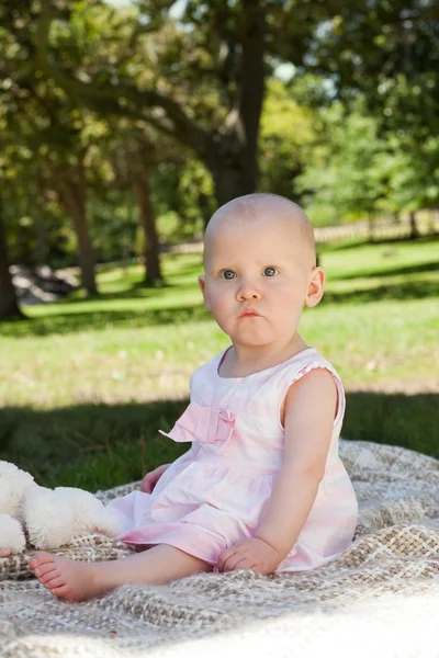 Carino bambino seduto su una coperta al parco — Foto Stock