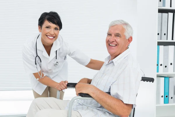 Female doctor with senior patient in wheelchair — Stock Photo, Image