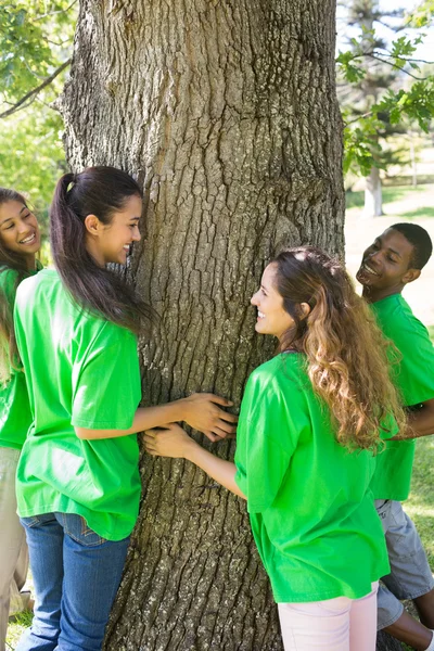 Umweltschützer stehen um Baumstamm herum — Stockfoto