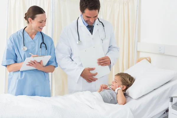 Médicos atendiendo a chica enferma —  Fotos de Stock