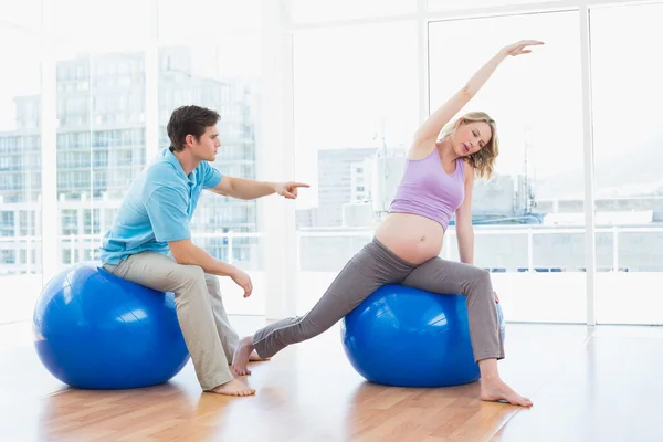 Trainer exercising with pregnant client — Stock Photo, Image