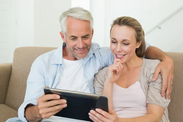 Szczęśliwa para przy użyciu komputera typu tablet pc razem na kanapie — Zdjęcie stockowe