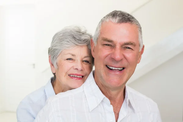 Casal aposentado sorrindo para a câmera — Fotografia de Stock
