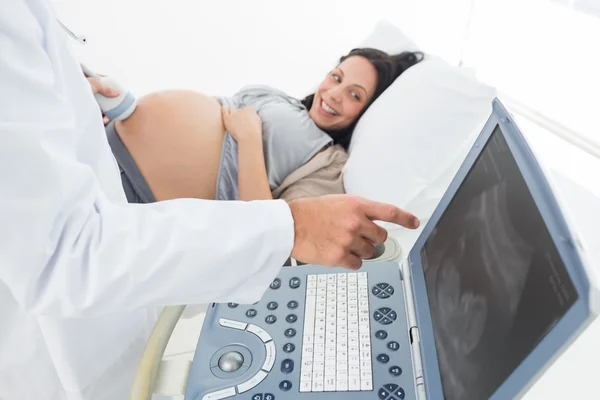 Médico mostrando monitor de ultra-som para mulher grávida — Fotografia de Stock