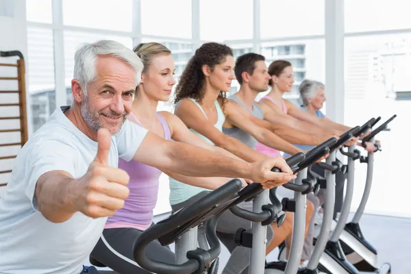 Man gesturing thumbs up with class at spinning class — Stock Photo, Image