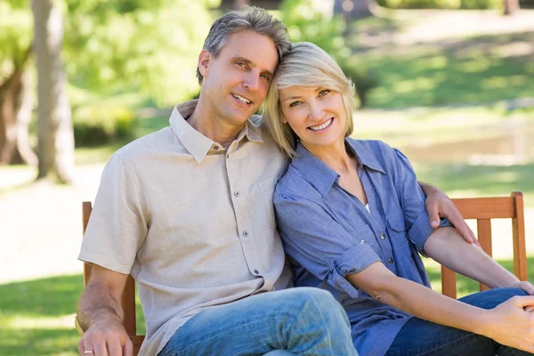 Affectionate couple sitting on bench — Stock Photo, Image