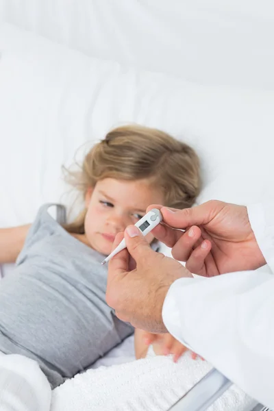 Médico segurando termômetro com menina doente — Fotografia de Stock