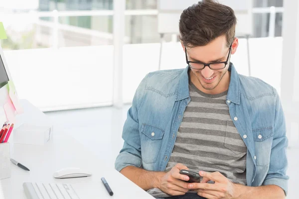 Male artist text messaging in front of computer — Stock Photo, Image