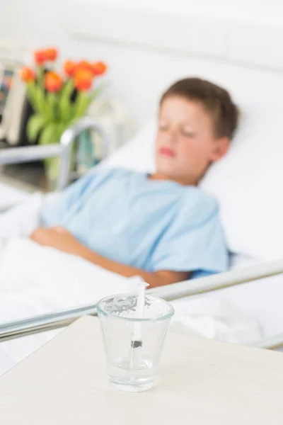 Syringe in glass with boy in hospital — Stock Photo, Image