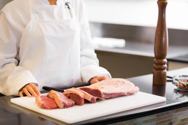 Chef com pedaços de carne cortada — Fotografia de Stock