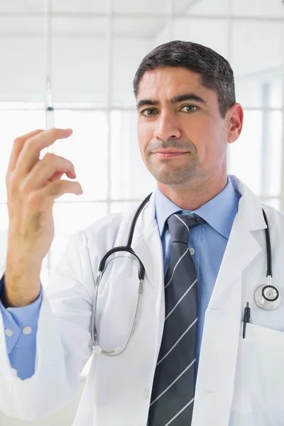 Retrato del médico varón que sostiene una inyección — Foto de Stock