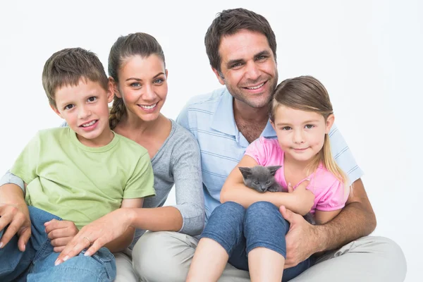 Cute family with pet kitten posing and smiling at camera together — Stock Photo, Image