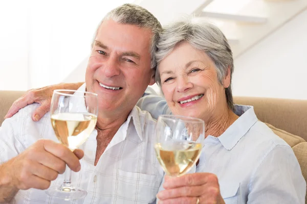 Seniorenpaar sitzt auf Couch und trinkt Weißwein — Stockfoto