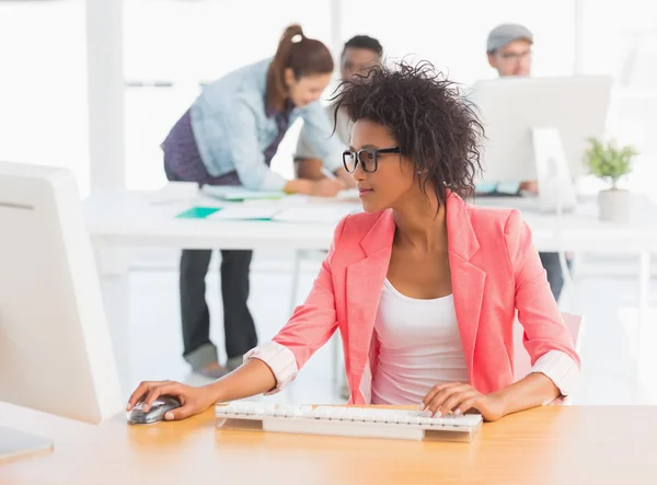 Female artist using computer with colleagues — Stock Photo, Image