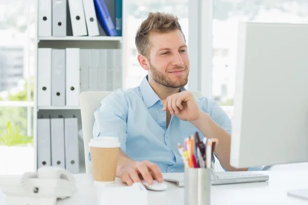 Homme souriant travaillant à son bureau — Photo