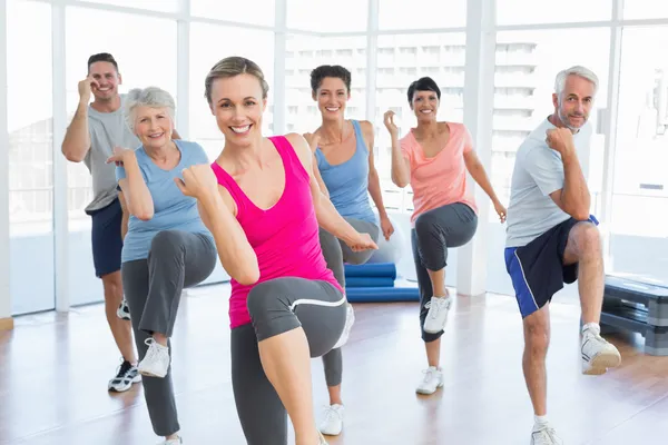 Pessoas sorrindo fazendo exercício de fitness de poder na aula de ioga — Fotografia de Stock