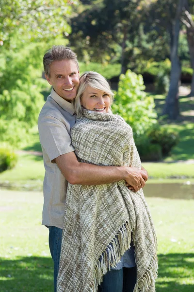 Smiling couple embracing in park — Stock Photo, Image