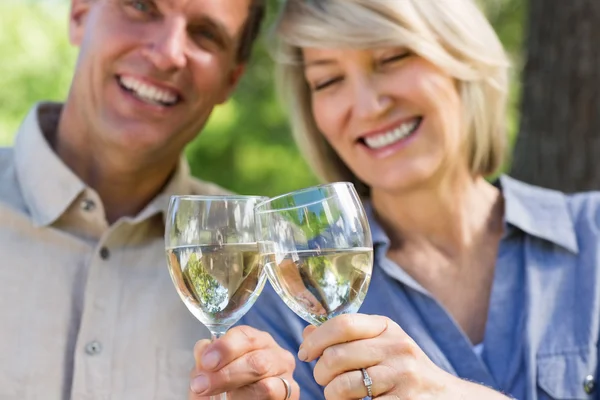 Lächelndes Paar beim Anstoßen auf Weingläser — Stockfoto