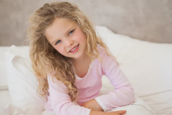 Sorrindo menina sentada na cama — Fotografia de Stock