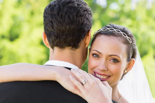 Glückliche Braut umarmt Bräutigam — Stockfoto