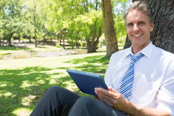 Uomo d'affari con tablet digitale nel parco — Foto Stock