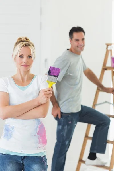 Casal com pincel e escada de pintura — Fotografia de Stock