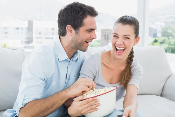 Paar schaut lustigen Film auf dem Sofa mit Schüssel Popcorn — Stockfoto