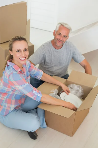 Happy couple unpacking cardboard moving boxes — Stock Photo, Image