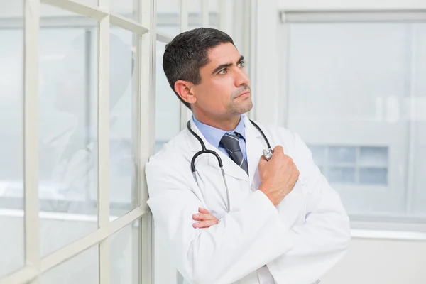 Thoughtful male doctor looking away in hospital — Stock Photo, Image