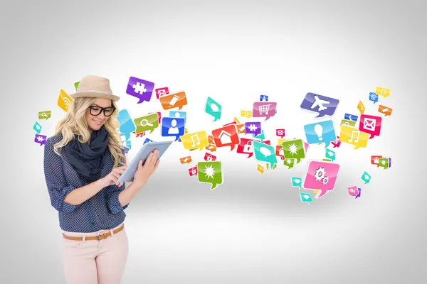 Stylish blonde using tablet pc with app icons — Stock Photo, Image
