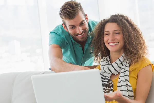 Sorrindo mulher mostrando seu colega de trabalho seu laptop — Fotografia de Stock