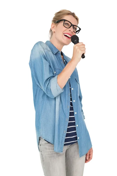 Beautiful young woman singing into a microphone — Stock Photo, Image