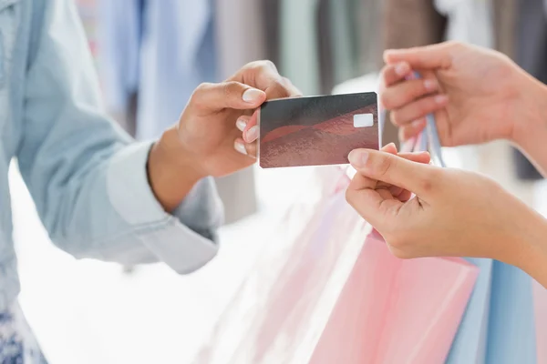 Mid section of customer receiving shopping bags and credit card — Stock Photo, Image