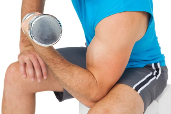 Mid section of a fit man exercising with dumbbell — Stock Photo, Image