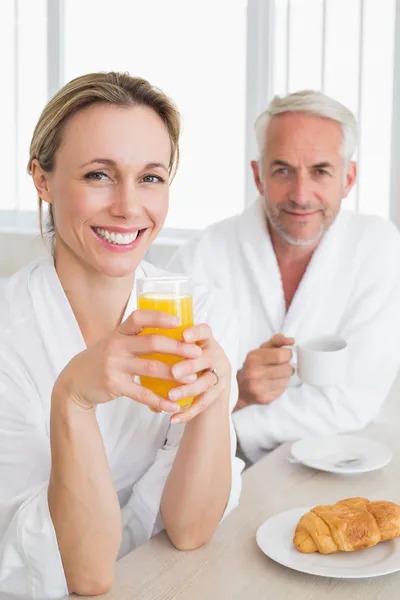 Happy couple having breakfast in bathrobes — Stock Photo, Image
