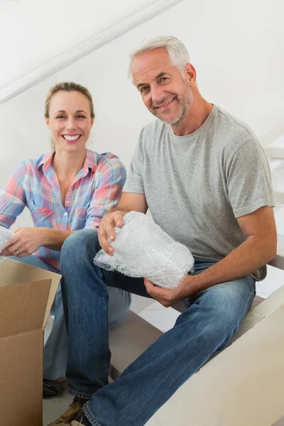 Happy couple unpacking cardboard moving boxes — Stock Photo, Image