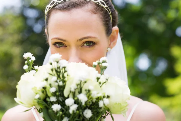 Braut blickt über Strauß im Garten — Stockfoto