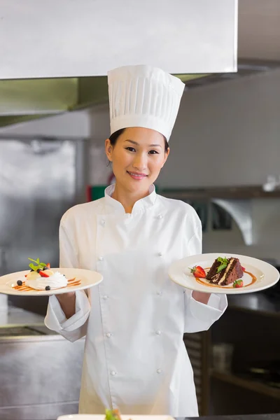 Chef femme confiante tenant des aliments cuits dans la cuisine — Photo