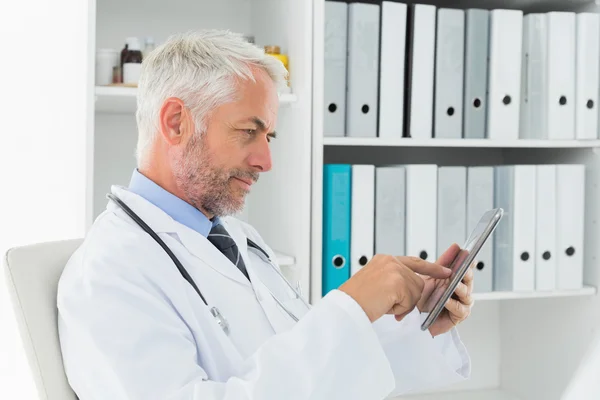 Concentrated doctor using digital tablet at medical office — Stock Photo, Image